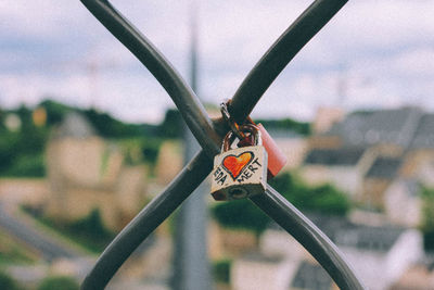 Close-up of metal chain against sky