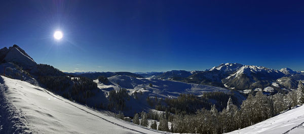 Scenic view of snowcapped mountains against blue sky