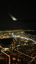 Aerial view of illuminated cityscape against sky at night