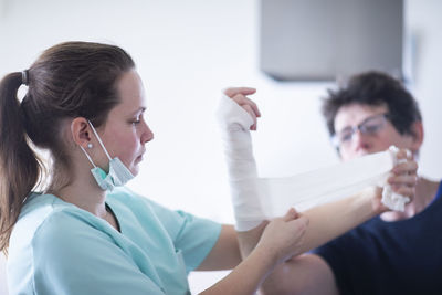 Nurse making a armwraps to a patient female