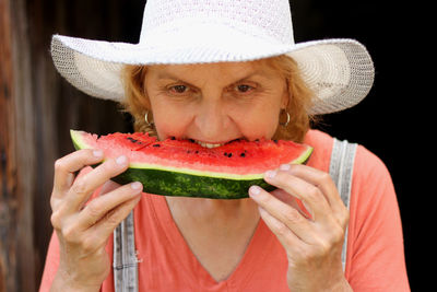 Senior woman eating watermelon indoor