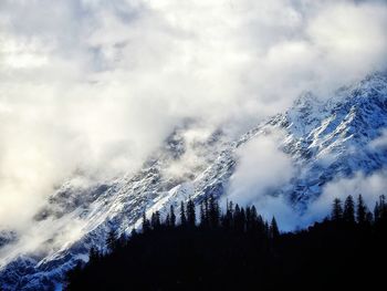 Low angle view of snowcapped mountains against sky