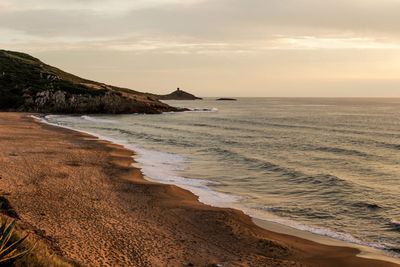 Scenic view of beach against sky during sunset