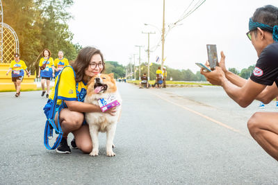 Portrait of woman with dog on mobile phone