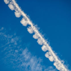 Fluffy chemtrail or contrail overhead against blue sky