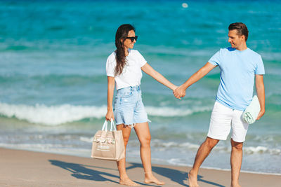 Rear view of couple standing at beach