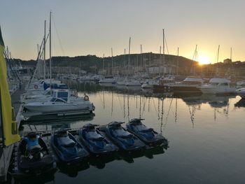 Sailboats moored at harbor