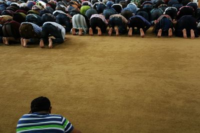People kneeling and praying on ground
