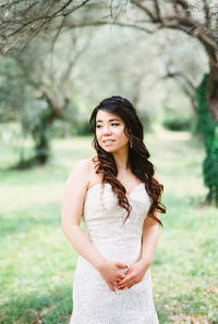 Portrait of smiling young woman standing on field