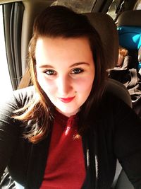 Portrait of smiling young woman sitting in car