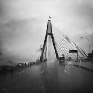 Bridge over river in city against sky