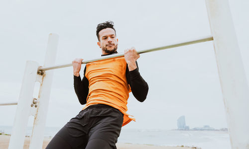 Portrait of young man exercising at beach