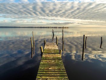 Wooden pier on lake against sky