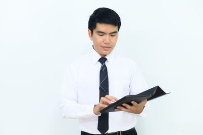 Young man looking away against white background