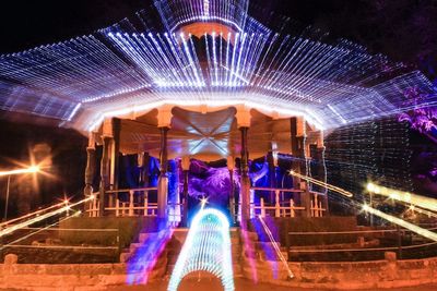 Illuminated light trails on fountain in city at night