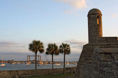 View of historical building by sea against sky