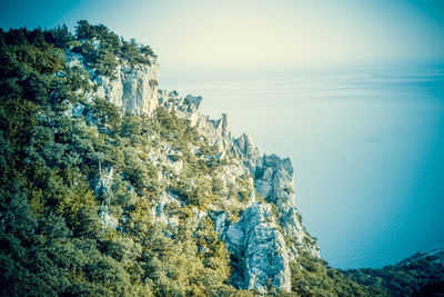 Rock formation in sea against sky