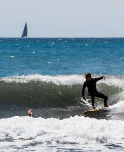 Man surfing in sea against sky