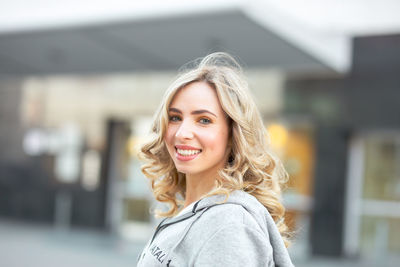 Portrait of smiling young woman in city