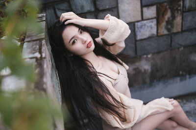 Portrait of young woman sitting at home