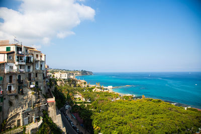 High angle view of townscape by sea against sky