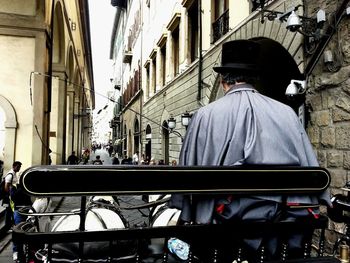 Rear view of man walking on street in city