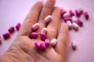 Cropped hand of person holding medicines on table