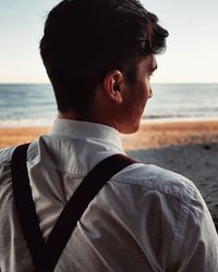 Rear view of man standing at beach