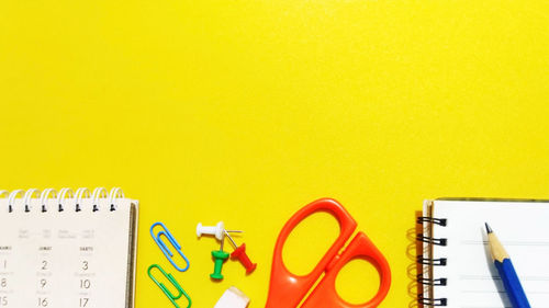 Close-up of pencils on table against yellow background