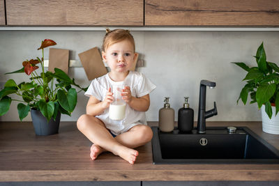 Portrait of cute baby boy sitting at home