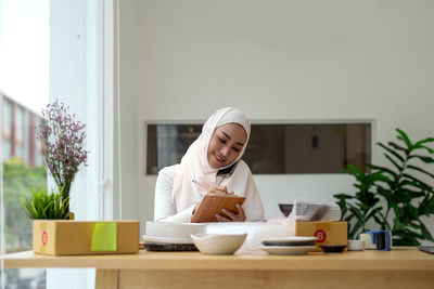 Young woman using laptop while sitting at home