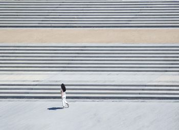 High angle view of woman walking by steps