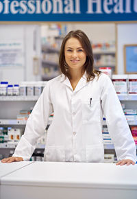 Portrait of young pharmacist standing in pharmacy