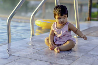 Portrait of cute baby boy sitting on floor