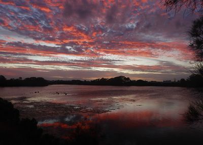 Scenic view of lake against orange sky
