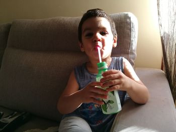 Boy sitting on sofa at home