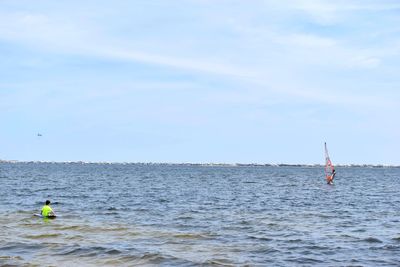 Rear view of man in sea against sky