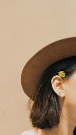 Cropped image of young woman against wall