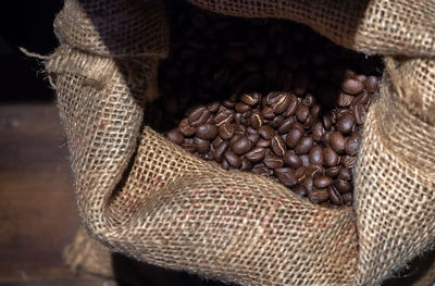 High angle view of roasted coffee beans in sack on table