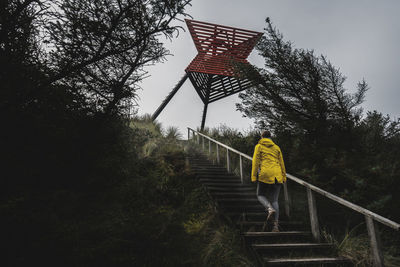Rear view of man on staircase against sky
