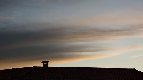 Low angle view of house roof against sky