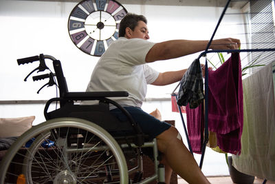 A disabled person on a wheelchair washes laundry