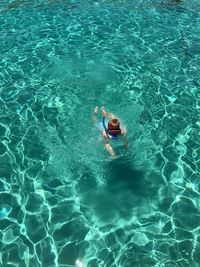 High angle view of child swimming in sea