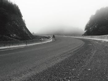 Road by mountains against sky