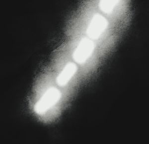 Close-up of illuminated light bulb against wall