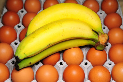 High angle view of bananas on brown eggs in carton