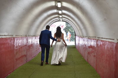 Rear view of couple walking in corridor