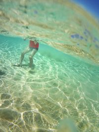 Low section of man swimming in sea