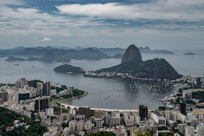 High angle view of city by sea against sky