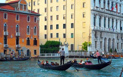 Boats in canal against buildings in city